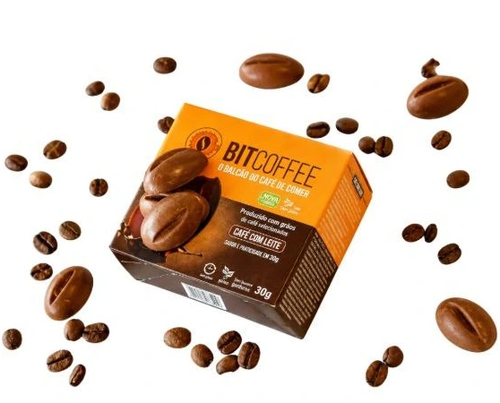 Caixa do café de comer Bitcoffee, cercada por grãos de café
